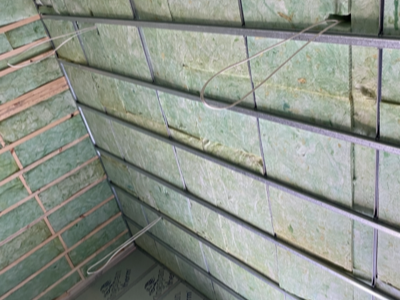 Green Earthwool batts fitted to walls and ceiling on a combined insulation job